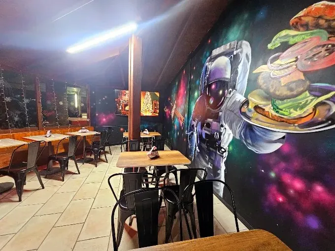 Dining room with a mural of an astronaut holding a burger