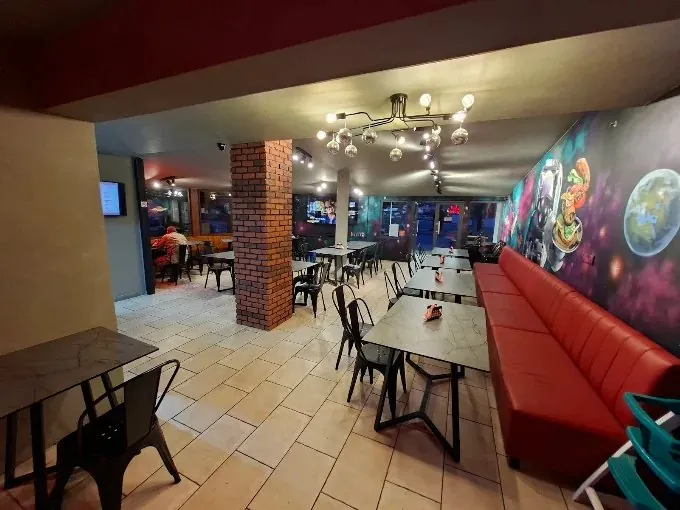 Wide view of the restaurant with red booth seating